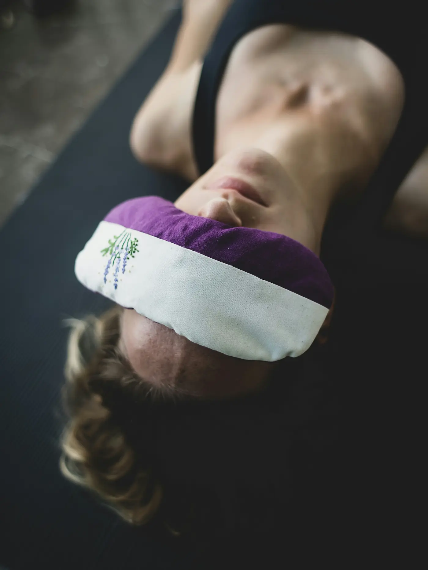 woman with eye mask on her eyes during yoga nidra practice