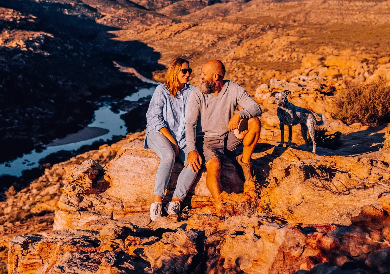 Couple sitting on rocks above the Doring River at sunset, Cederberg Mountains, Bliss and Stars retreat