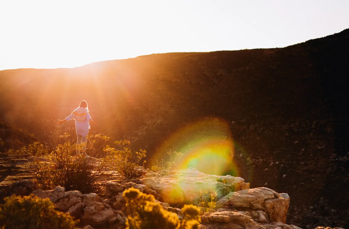 Guest at sunrise on a Cederberg ridge during Bloom ceremony retreat at Bliss and Stars, Western Cape, South Africa